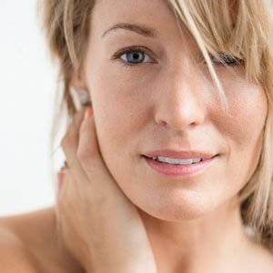 image of woman applying lotion to shoulder